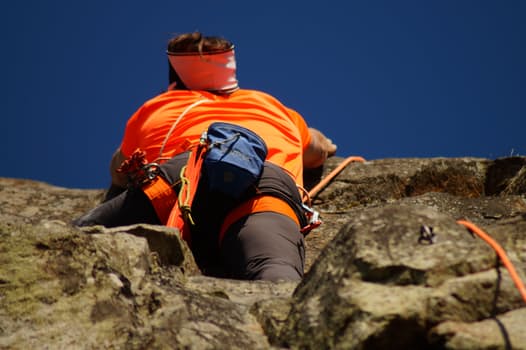 Young man climbing a cliff